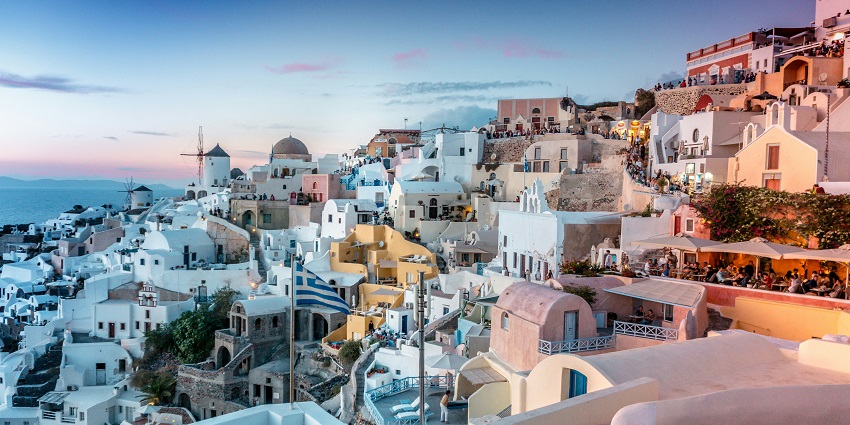 Whitewashed cliffside houses in Oia, Santorini, under the sky, one of the best places to visit near Turkey.
