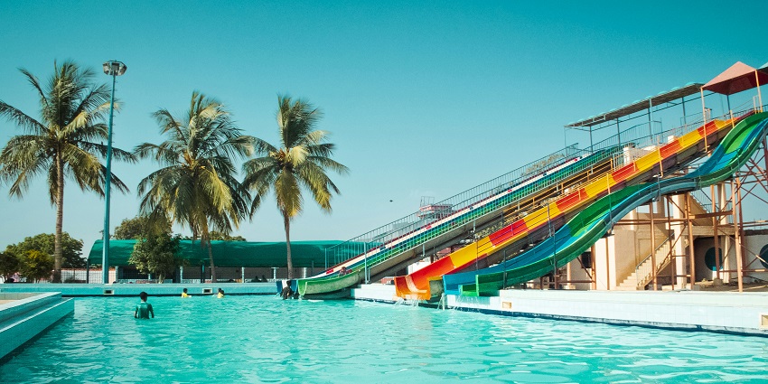 A swimming pool with a colorful water slide at Hays Aquatic Park.
