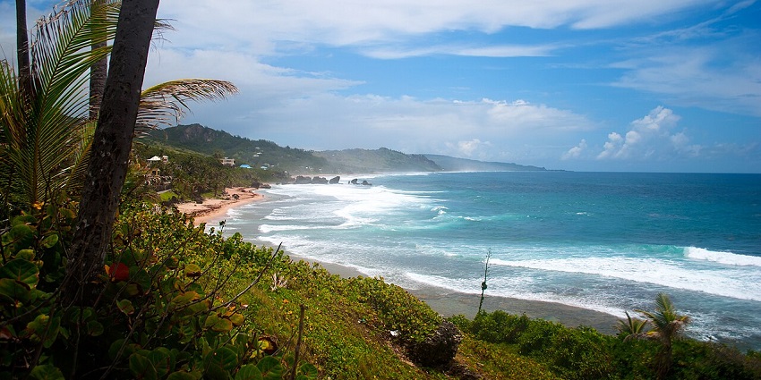 East coast of Barbados from the east coast trail with high tide water of the ocean and sandy shore.