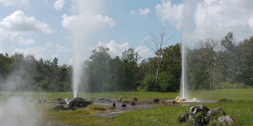 Steam rises from geysers at San Kamphaeng Hot Springs, with rocky ground, amongst the places to visit near Chiang Mai.