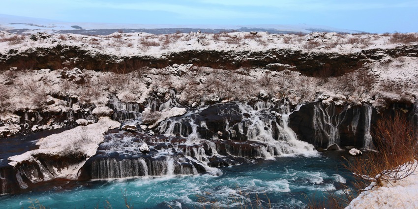 Hraunfossar and Barnafoss Waterfalls showcase contrasting flows in a stunning natural setting.