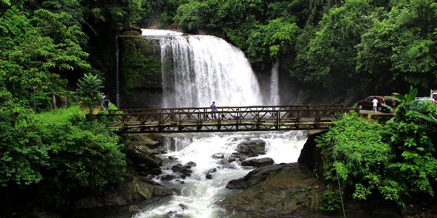A waterfall in Igatpuri is surrounded by lush greenery and rocky terrain.
