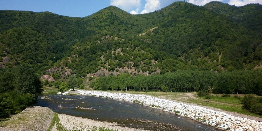 Aerial view of Iskar Gorge with river, stone shores, and forested mountains, one of the scenic places to visit near Sofia.