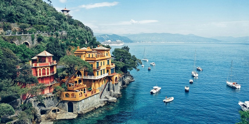 Portofino coastline with sea cliffs and clear blue waters under a bright sky.
