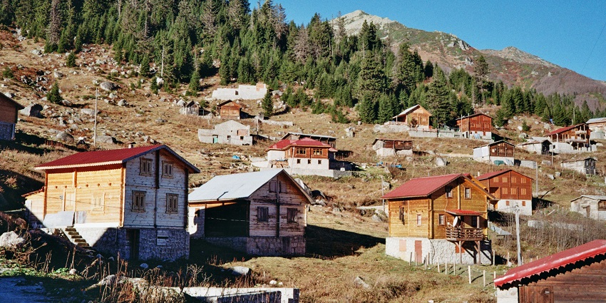 View of Ixtlahuacán De Los Membrillos town nestled among green hills and farmland.