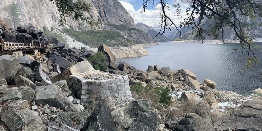 Salmon Falls Creek Reservoir with calm water and surrounding rocky hills under sky.
