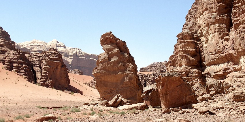 Vast desert landscape of Wadi Rum, Jordan, with towering sandstone rock formations.