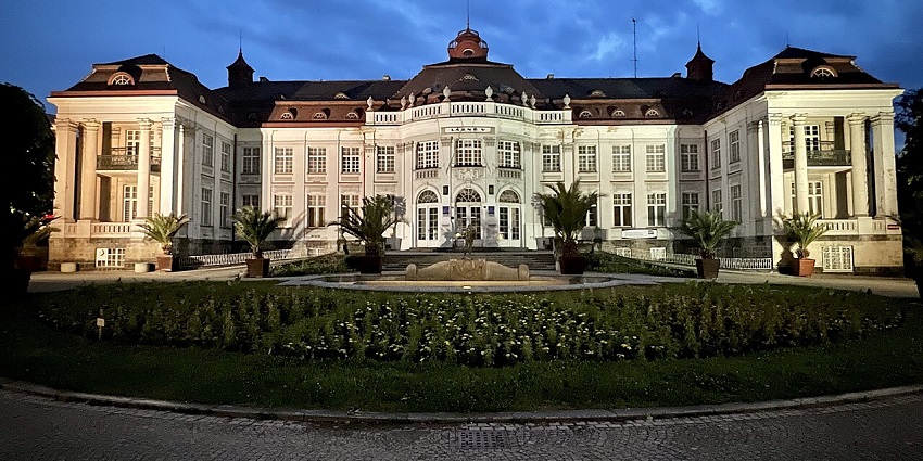 Elegant illuminated palace with a dome and a garden fountain, among the top places to visit near Prague.