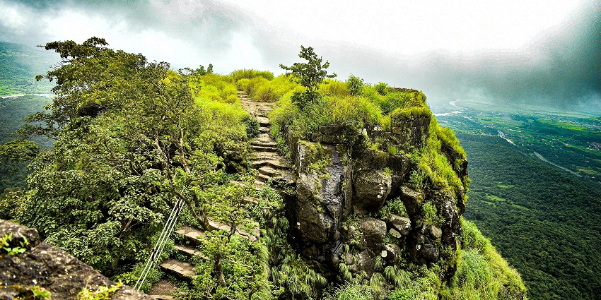 Karnala Fort stairs with greenery in bird sanctuary, places to visit for 1 night near Mumbai.
