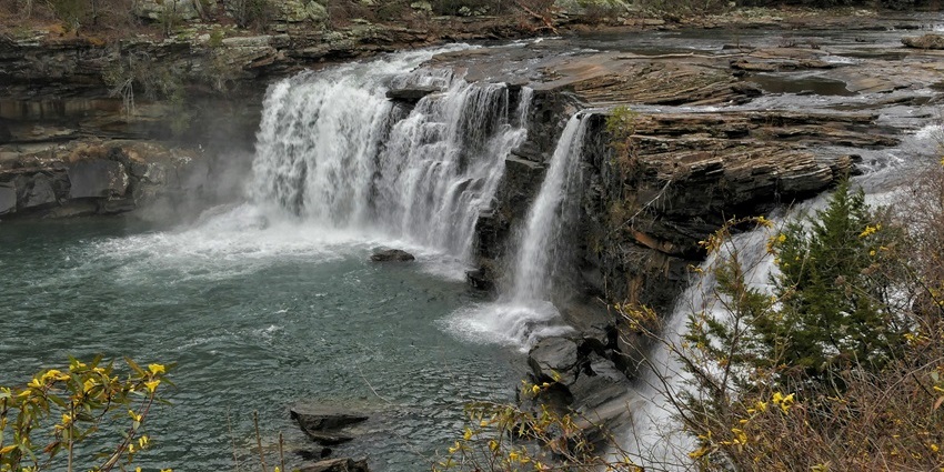 Cascading Smith Falls flows through rocky terrain and is surrounded by natural greenery.
