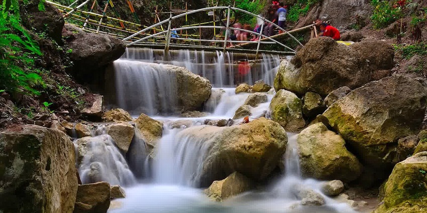 Refreshing Kedung Pedut Waterfall with clear turquoise pools, a serene place to visit near Yogyakarta.