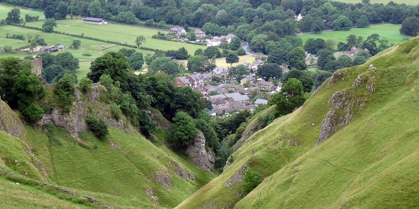 Town with similar looking buildings surrounded by greenery and hidden in between valleys.