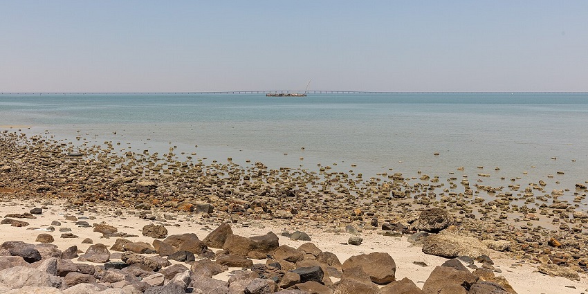 Sheikh Jaber Bridge with rocky shore in foreground, one of the iconic places to visit near Qatar.
