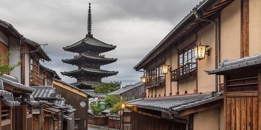 A traditional Japanese street with wooden houses and a tall pagoda, one of the top places to visit near Osaka.