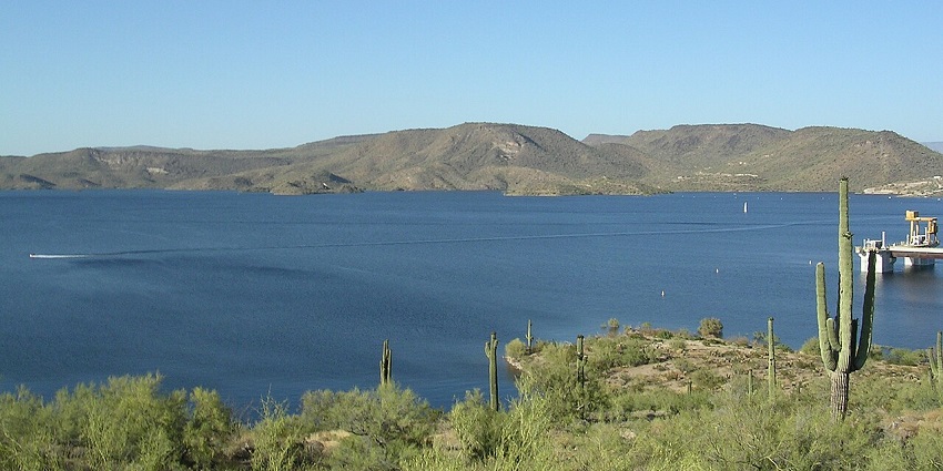 A scenic view of the Lake Pleasant featuring still blue water, one of the places to visit near Phoenix.