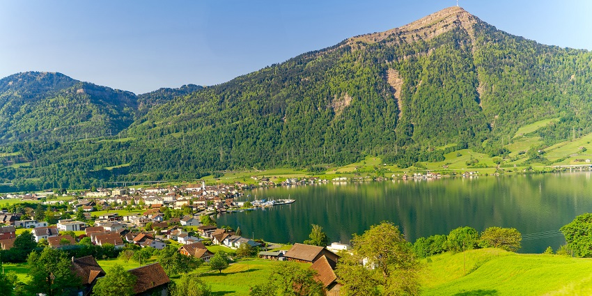 Lake Zug with calm water, mountain backdrop, and a town along the lakeshore.