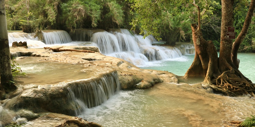 Kuang Si Falls with turquoise pools, a stunning highlight among beautiful places to visit near Nepal.
