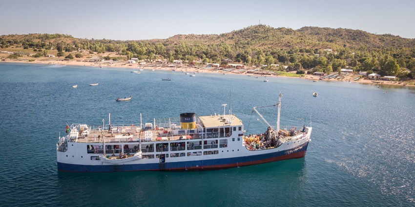 The Ilala ferry in Likoma Island, with calm waters and shoreline buildings, amongst the best places to visit in Malawi.