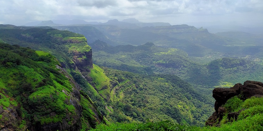 Serene view of the green hills in Lonavala under the cloudy sky, among the stunning places to visit for 1 night near Mumbai.
