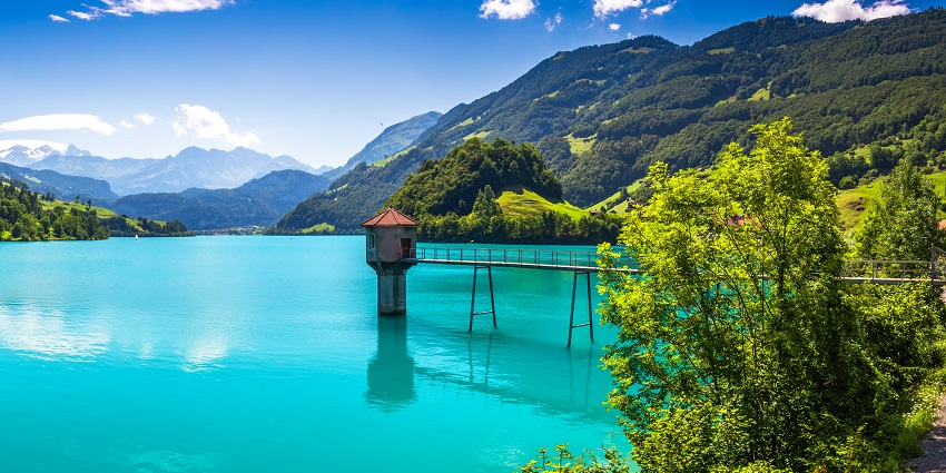 Scenic view of Lungernsee lake surrounded by mountains under a clear sky.