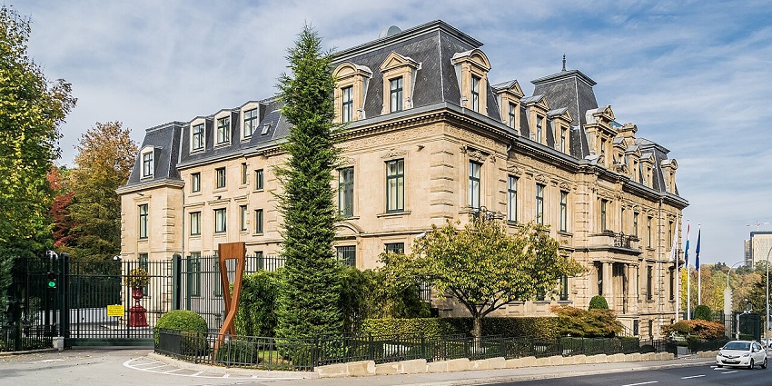 Central Bank of Luxembourg building with arched windows, a stone façade, and a road in front.