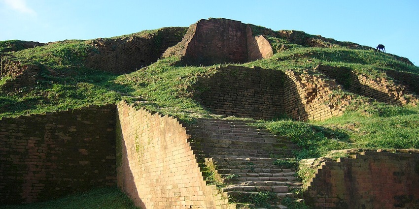 Mahasthangarh ruins feature ancient brick walls, archaeological sites, and open grassy areas.