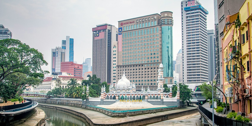 Kuala Lumpur city center showing Jamek Mosque surrounded by urban buildings and streets.
