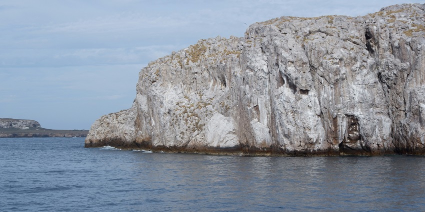 The Marietas Islands with sandy shore near a blue water body in a circular rocky structure, among the best places to visit near Puerto Vallarta.