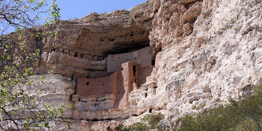 The ancient stone cliff dwelling of Montezuma Castle is nestled in a high limestone above the wall.