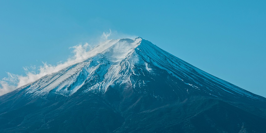 The snow-covered rocky ridge of Mount Inunaki is surrounded by peaceful winter forest scenery.