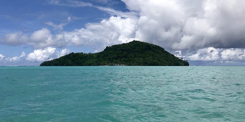 Namu’a Island stands lush and serene amid the turquoise waters of Samoa, framed by dramatic tropical skies.