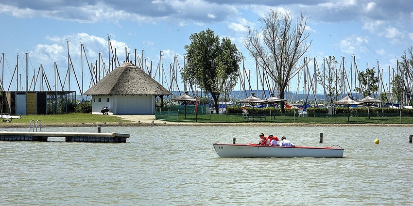 People yachting at Neusiedler See with calm lake water and distant shoreline views.