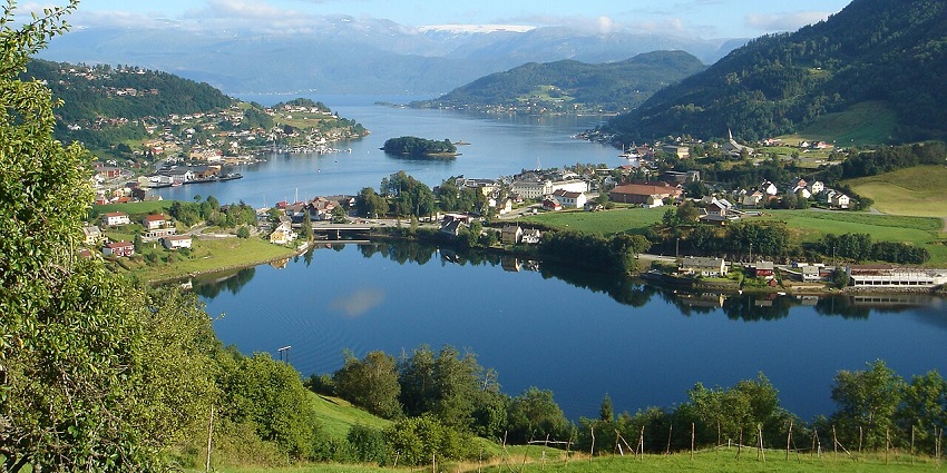 Norheimsund from above with distant buildings and green mountains, peaceful places to visit near Bergen.