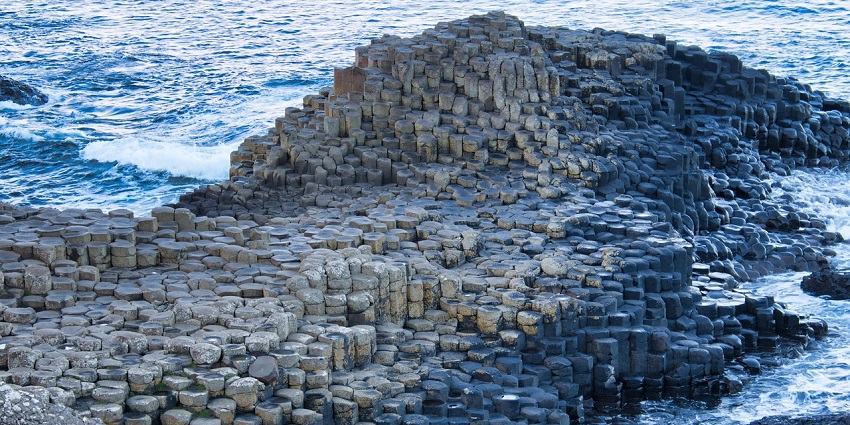 Giant’s Causeway with water hitting the rocks and stone structures in Northern Ireland.