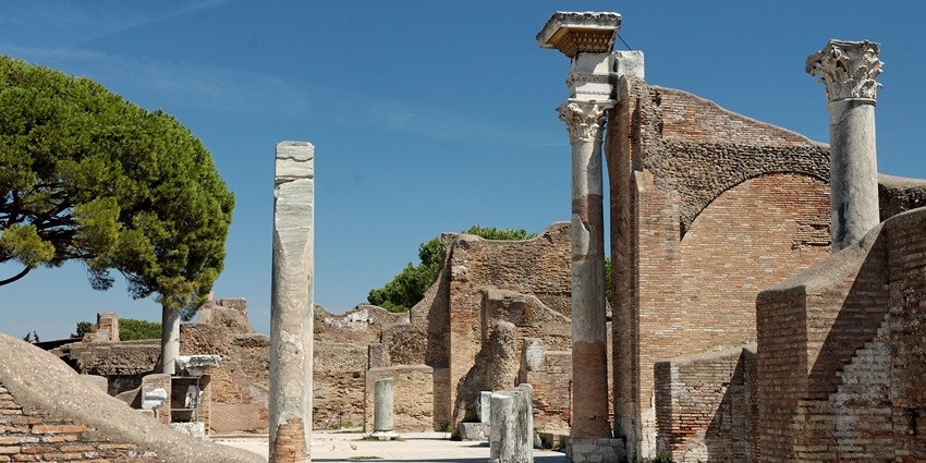 Ostia Antica with ancient architecture broken walls pillars and unique tree places to visit near Rome.