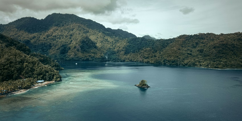 Scenic tropical island in Papua New Guinea with lush greenery and blue ocean waters.