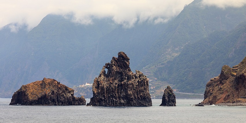 Dramatic coastal cliffs of Porto Moniz, a scenic gem among places to visit near Spain.
