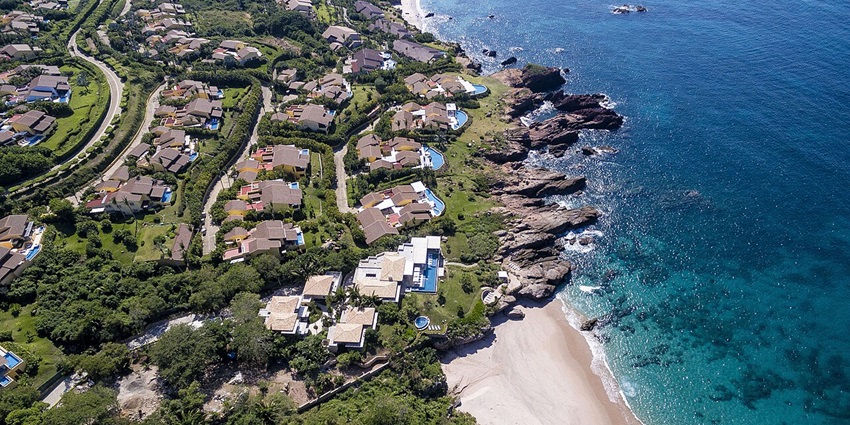 Punta Mita from above, with buildings, roads and greenery set in a unique design near the beach.