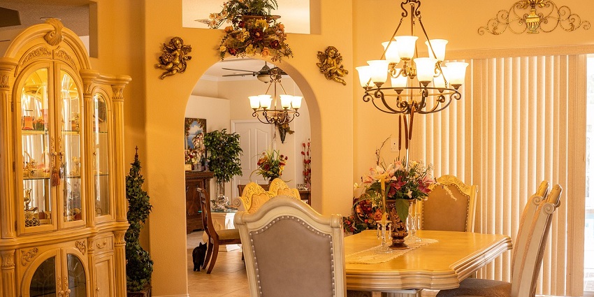 Indoor dining area with round tables, chandeliers, and neutral lighting in a hotel setting.