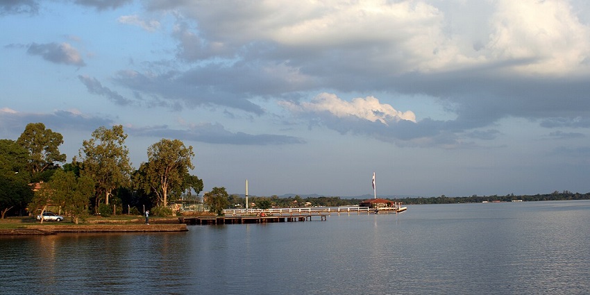 Enjoy Lake Ypacarai with calm waters, a pier, and tall green trees for things to do in Paraguay.