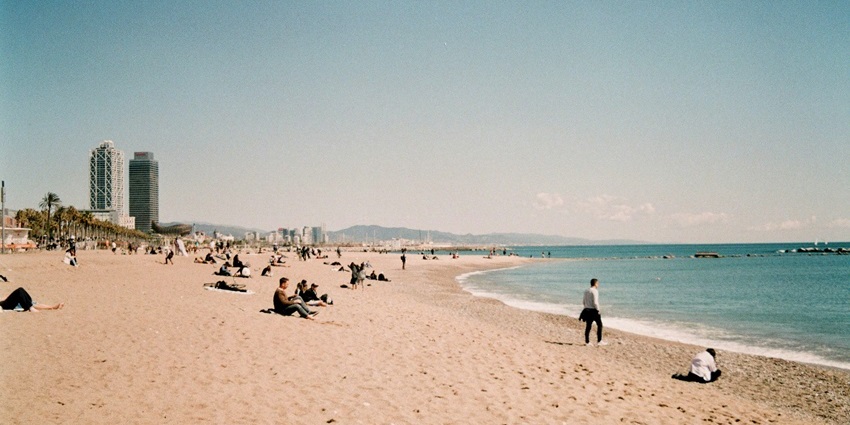 Visit Maiori beach with rows of blue umbrellas and sunbeds facing the sea, one of the best things to do in Maiori.