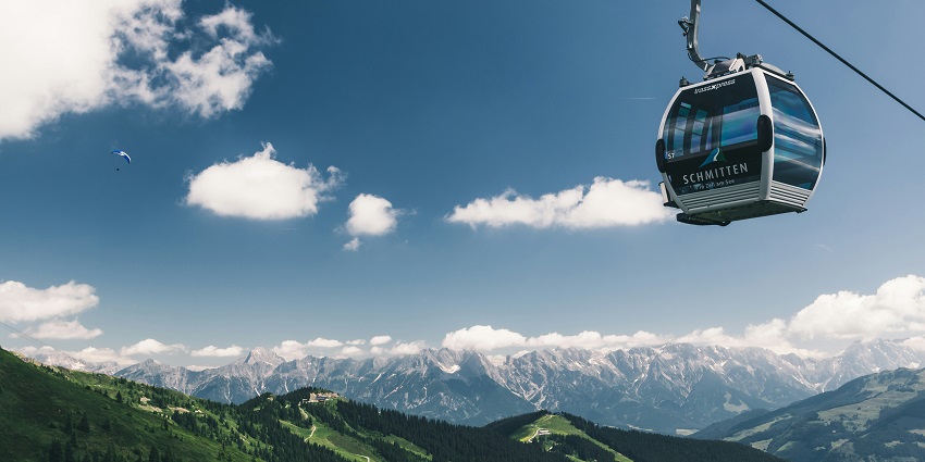 Cable car ascending Mount Roberts with forested slopes and scenic views in the background.