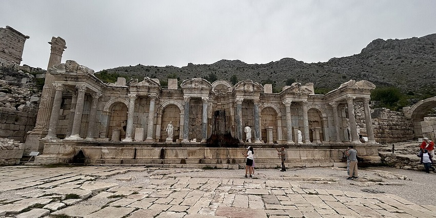 Visitors walk among ancient ruins and stone columns at the hillside site of Sagalassos.