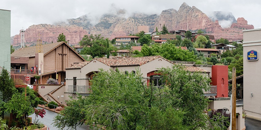 Scenic view of Sedona town with red rock formations, and many houses in the valley, one of the top places to visit near Phoenix.