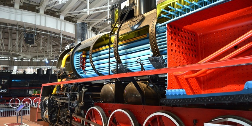 A sleek, modern train is displayed indoors at the SCMAGLEV Museum.