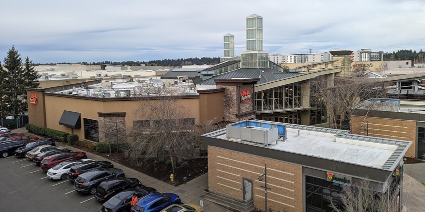 View of Alderwood Mall from the southwest parking garage with food court and parked cars.