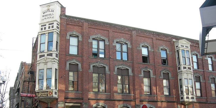 Historic red-brick building with bay windows, housing the Bread of Life Mission.