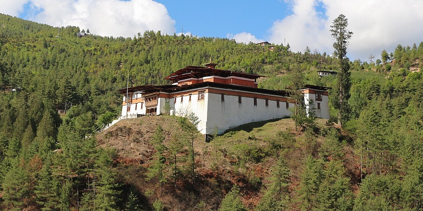 Simtokha Dzong, with its old dzong structure standing on a rocky mountain covered in greenery.
