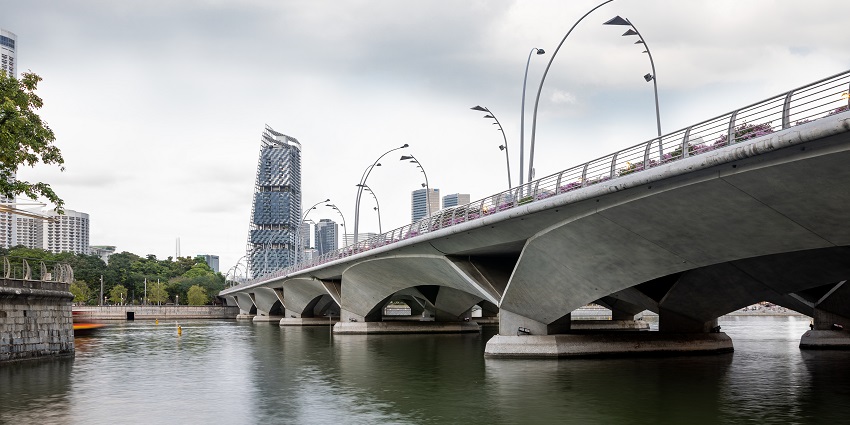 The Esplanade Bridge in Singapore spans Marina Bay with the city skyline in the background.