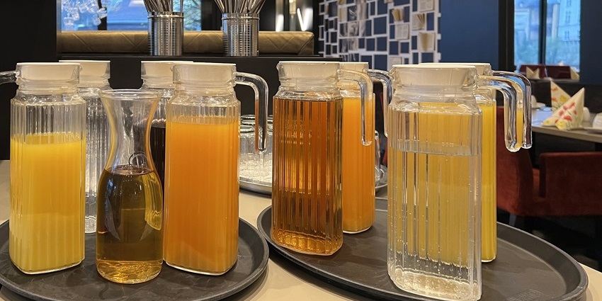 Yellow and orange bottled fruit juices are arranged on a counter, one of the best things to see in Makawao.